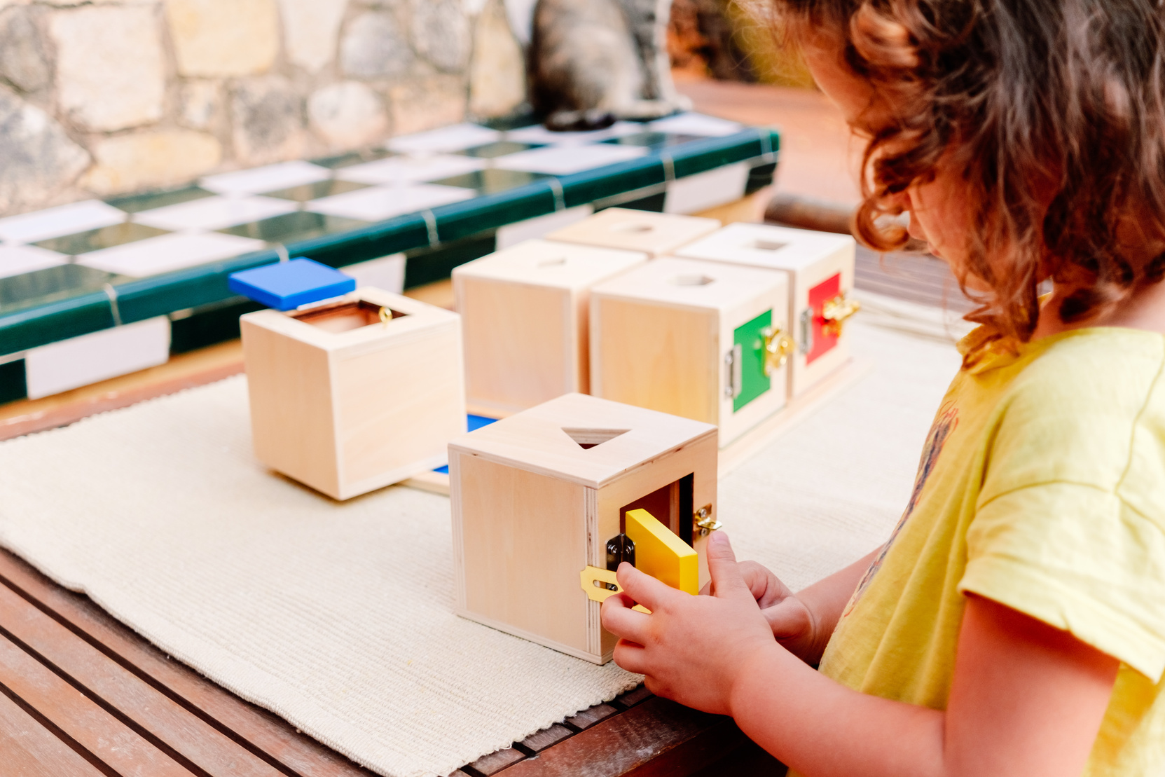 A Girl Manipulates Sensory Montessori Material, Wooden Boxes to